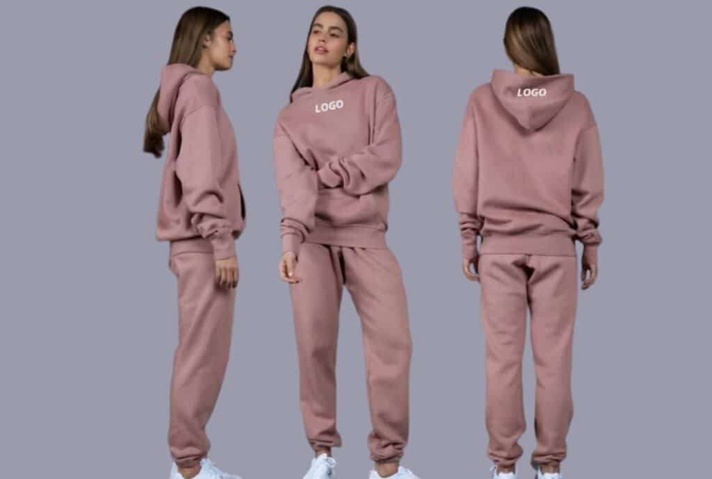 "Row of private label sweatsuits in assorted colors and sizes, neatly displayed on hangers with a clean showroom background."
