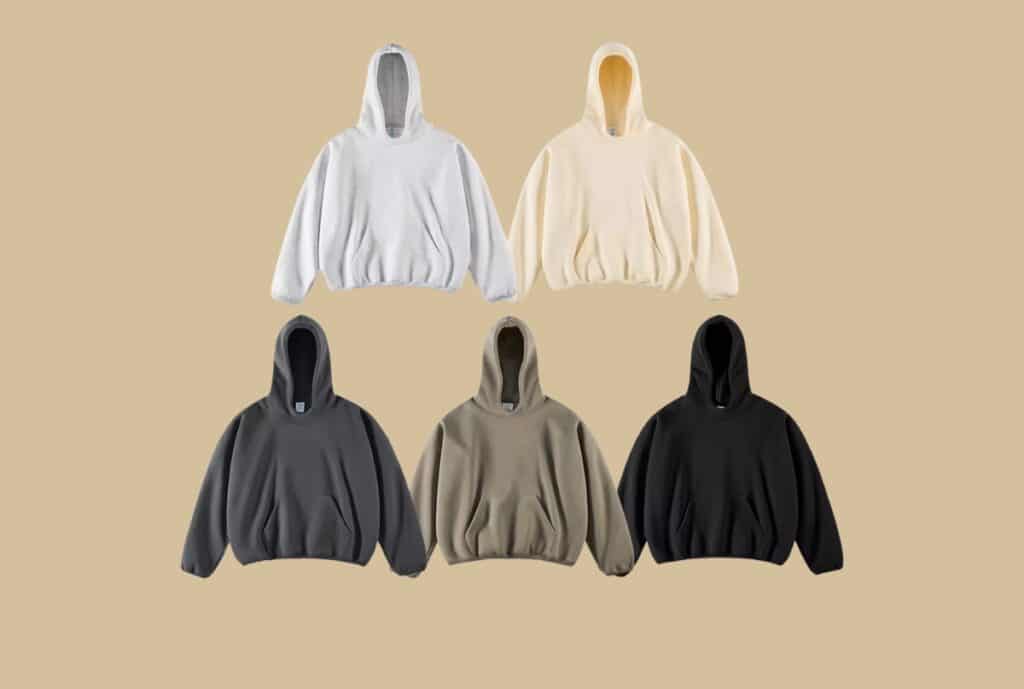 "A casual oversized hoodie hanging on a hanger against a neutral background."
