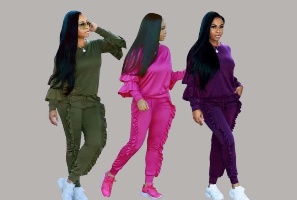 "Assorted sweatsuits in different colors lined up on racks with a 'Charlotte, NC' sign in the background."