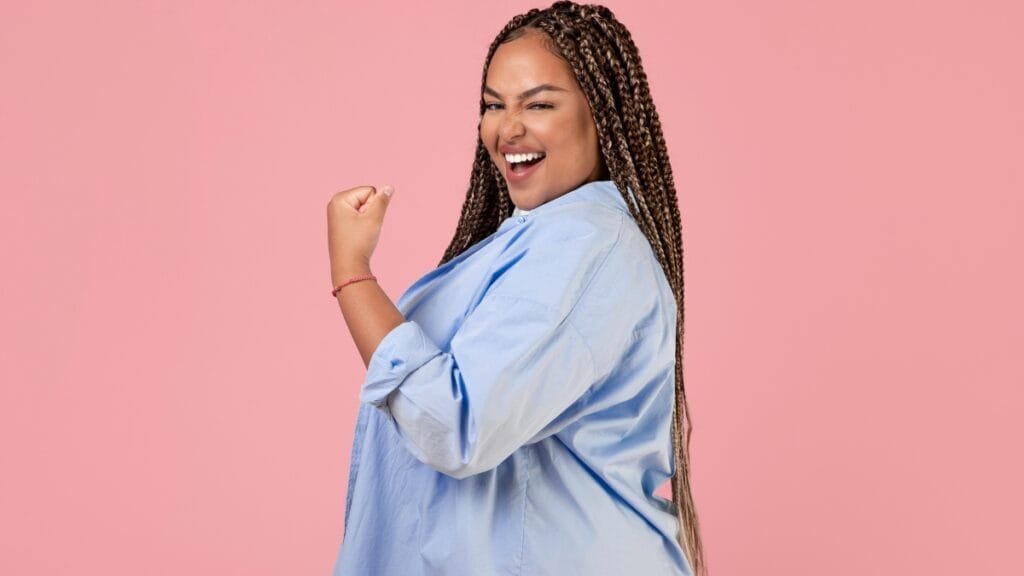 Curvy woman in a light blue plus size shirt, showing a strong, confident pose
