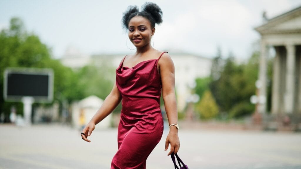 Stylish woman in a mauve velvet dress walking outdoor
