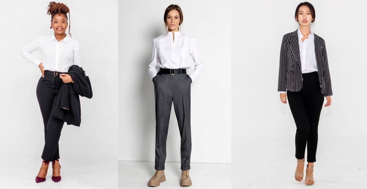 Elegant woman wearing a formal pant dress with a white shirt, a blazer, and heels, standing in a confident pose