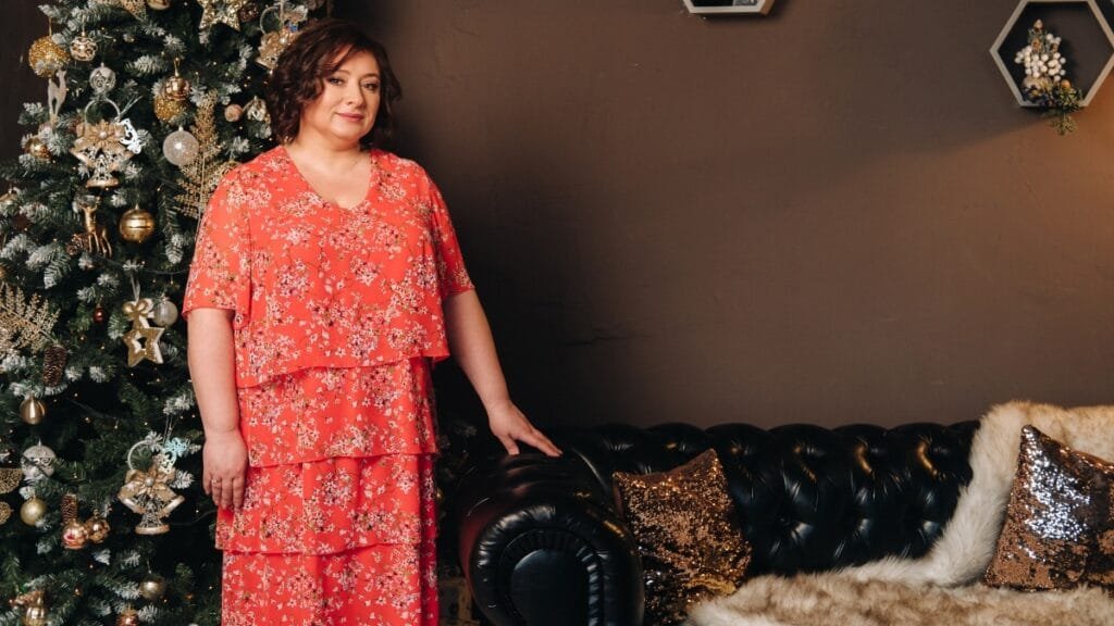 plus floral dress in a long-sleeve red floral print worn indoors with a cozy interior background