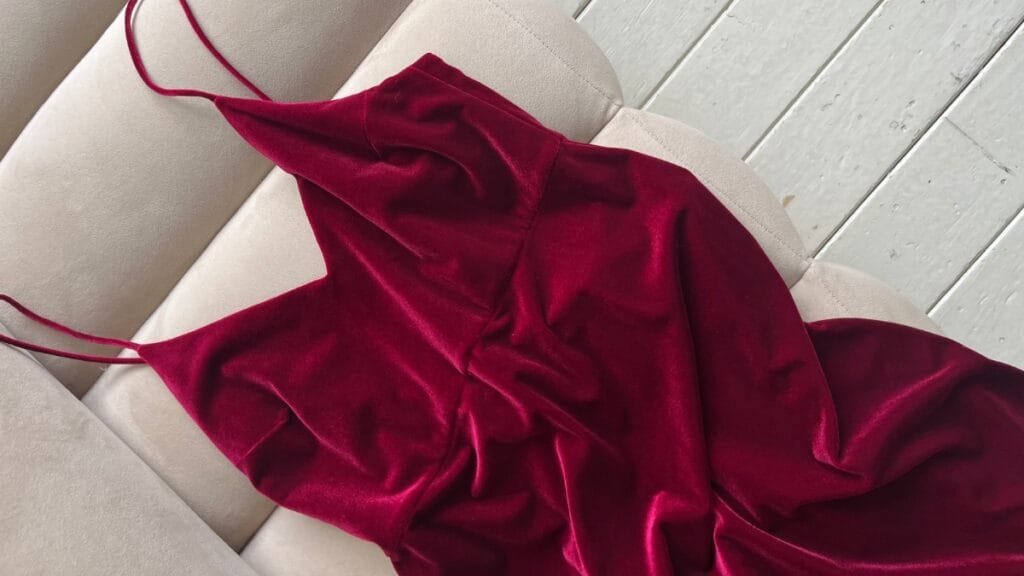 Red plus size velvet dress laid out on a white wooden floor