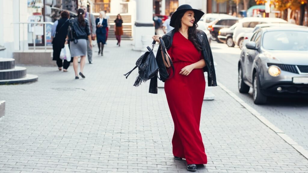 Woman walking outdoors in a red plus size velvet dress on a city street