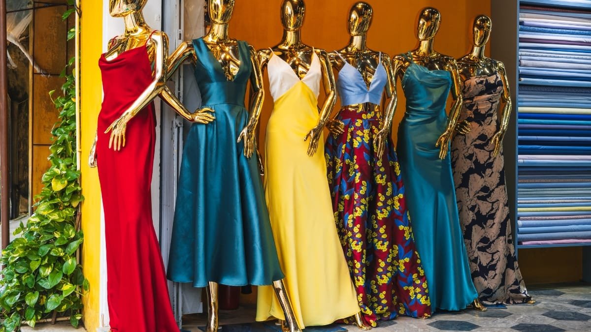 Display of colorful dresses on mannequins in a boutique window