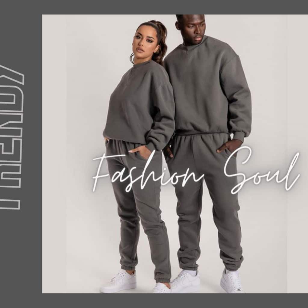 Two models in matching gray athleisure outfits (sweatshirt and joggers) stand side by side; white cursive text “Fashion Soul” overlays the image on a light background with a dark gray frame.