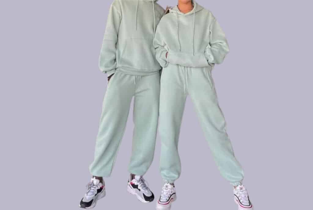 Factory workers inspecting fabric swatches for custom sweatsuits in a Los Angeles-based apparel manufacturing facility.