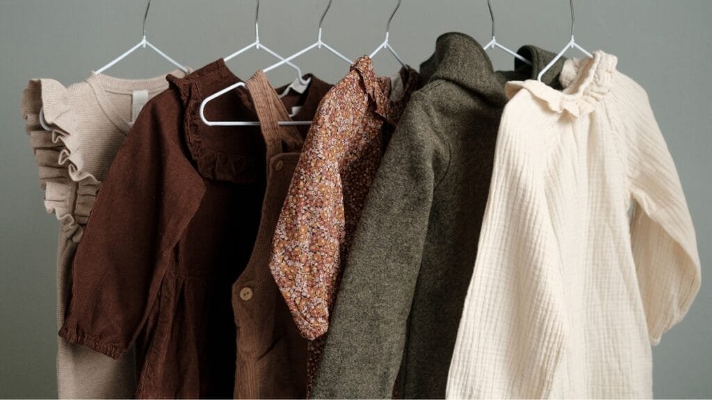 Clothes for 9-year-olds hanging on hangers, showcasing a variety of dresses and outerwear