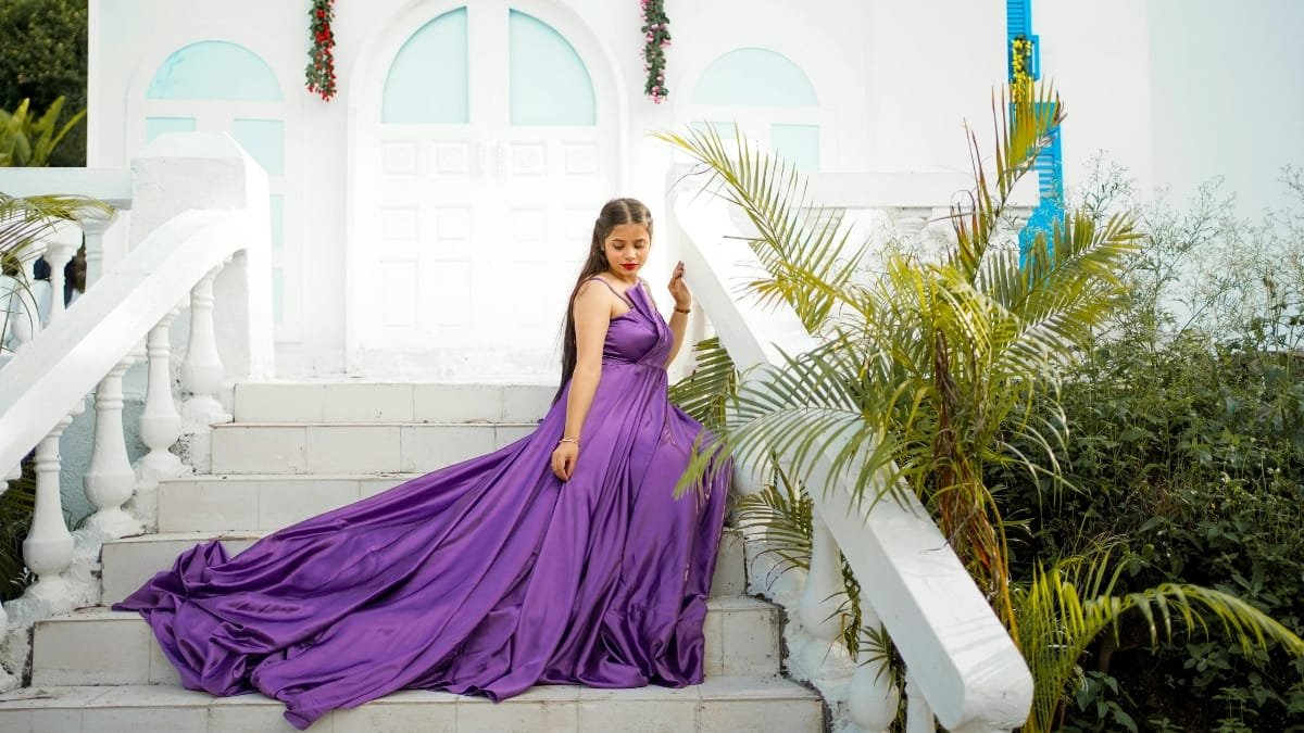 Plus size evening gown in purple, flowing elegantly on a staircase