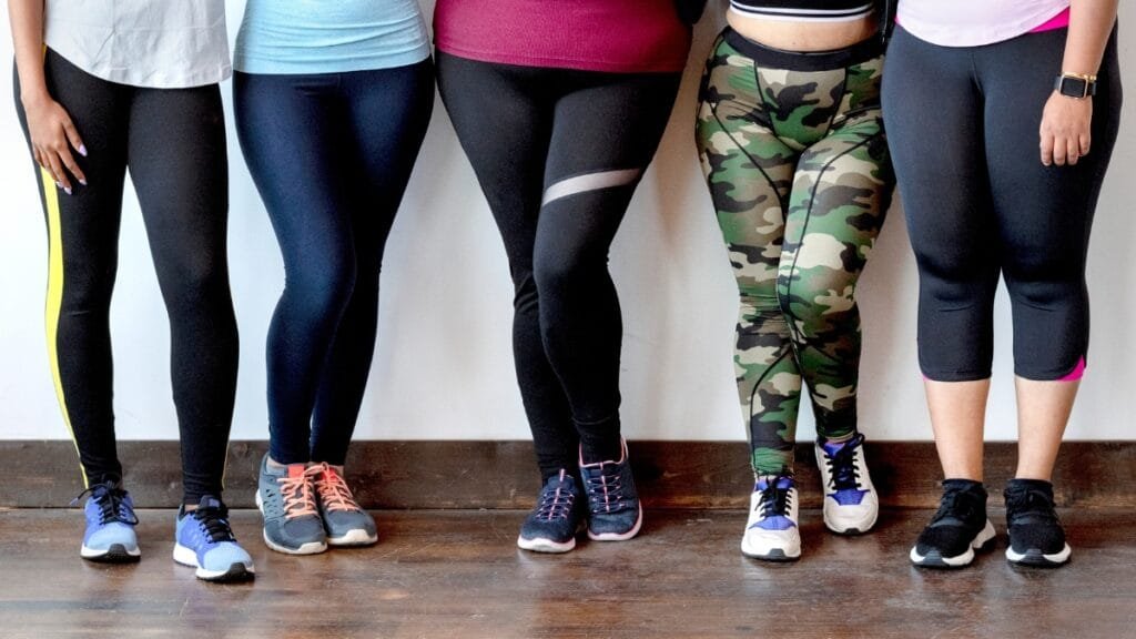 A diverse group of women in different styles of plus size track pants, showcasing variety and comfort.