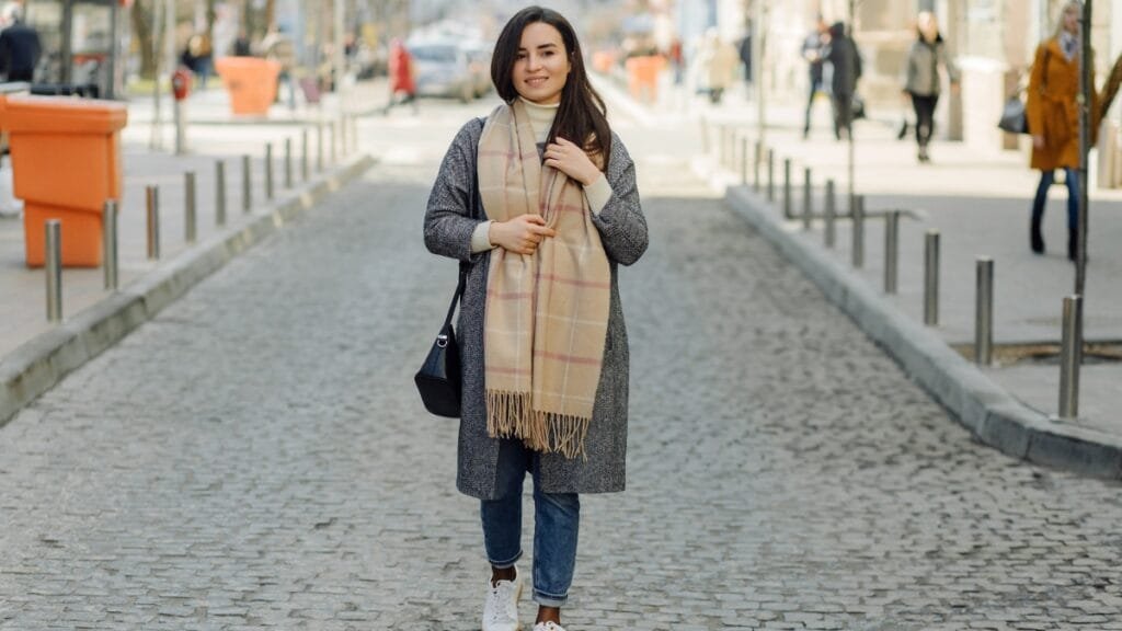Shop junior plus size clothing - stylish woman in a scarf and coat on city street