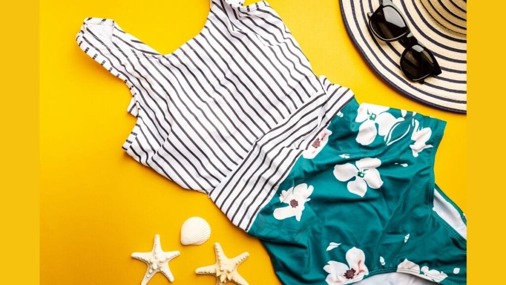 Flat-lay of swim tankini pieces and beach accessories on a bright yellow background