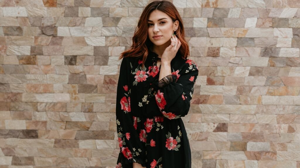 Close-up of a woman in a velvet floral dress, highlighting the intricate floral details.