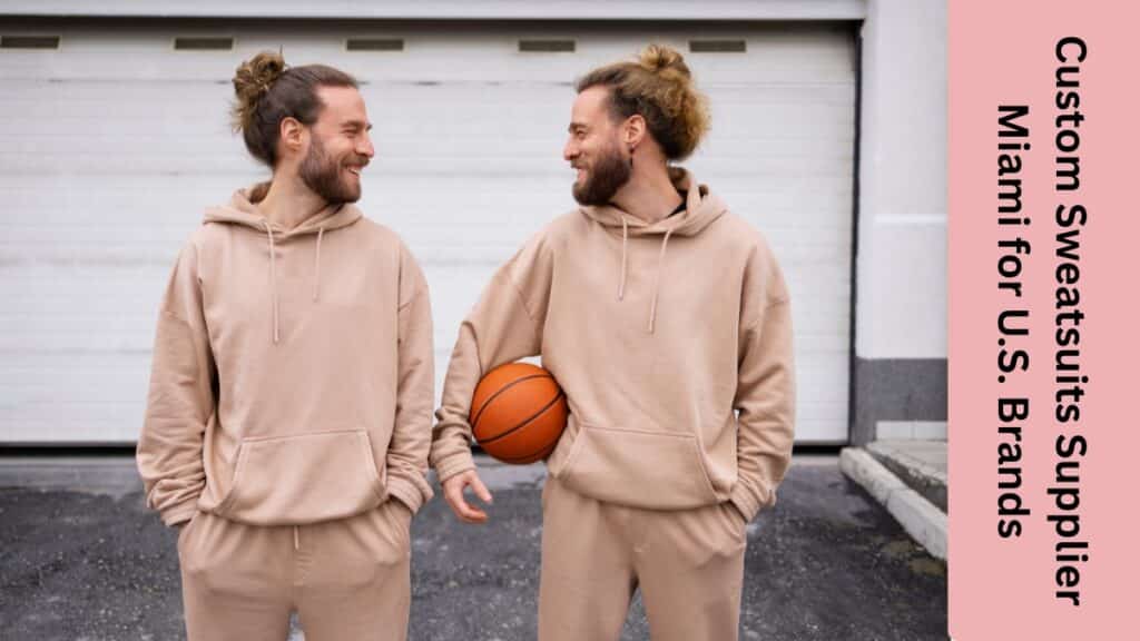 Wholesale custom sweatsuits displayed on racks in a Miami manufacturing facility, showing matching hoodies and jogger pants in navy and charcoal.