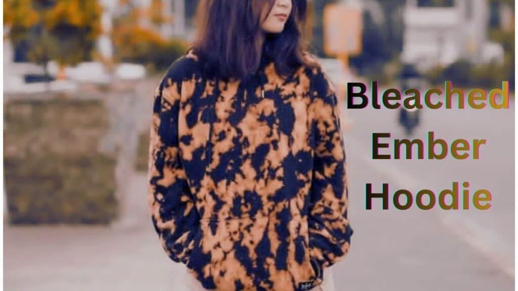 Person wearing a black hoodie with a bleach-style gradient to burnt orange, featuring a vivid orange-black print across the front and sleeves.