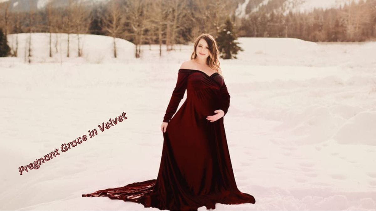 Pregnant woman wearing a red velvet gown in the snow.