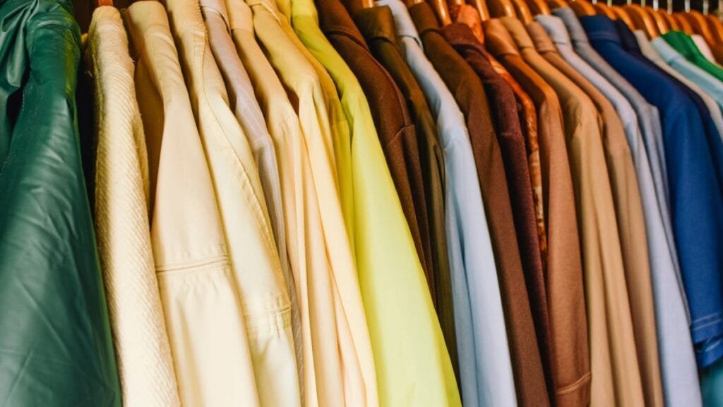 A collection of shirts in various colors hanging neatly in a wardrobe.