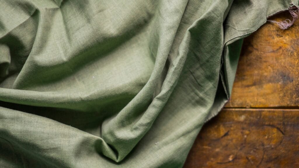 Close-up of a green fabric, showcasing one of the best clothing materials for comfort and style.