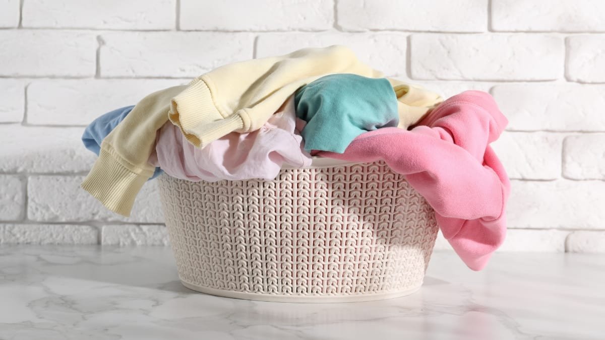 Laundry basket filled with clothes washed on delicate, featuring a variety of pastel-colored garments