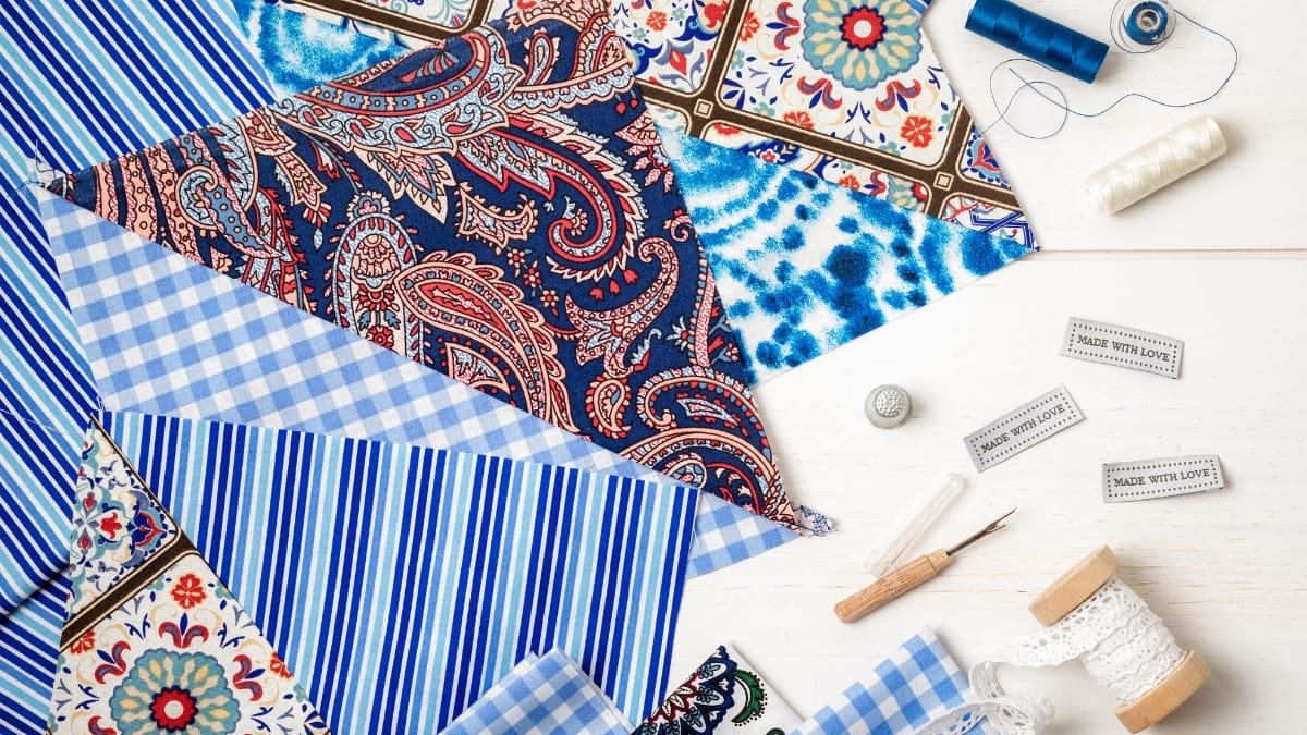A selection of various fabric prints, including paisley, striped, and floral patterns with sewing accessories