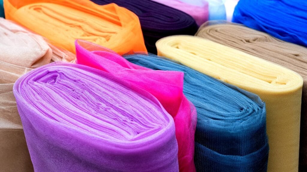 Rolled sheer fabric swatches in various vibrant colors, perfect for creative design projects