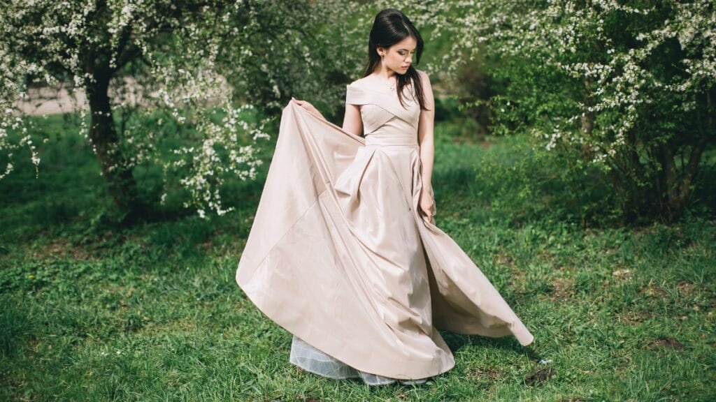 Size 16 prom gown in light beige, flowing gracefully in a garden
