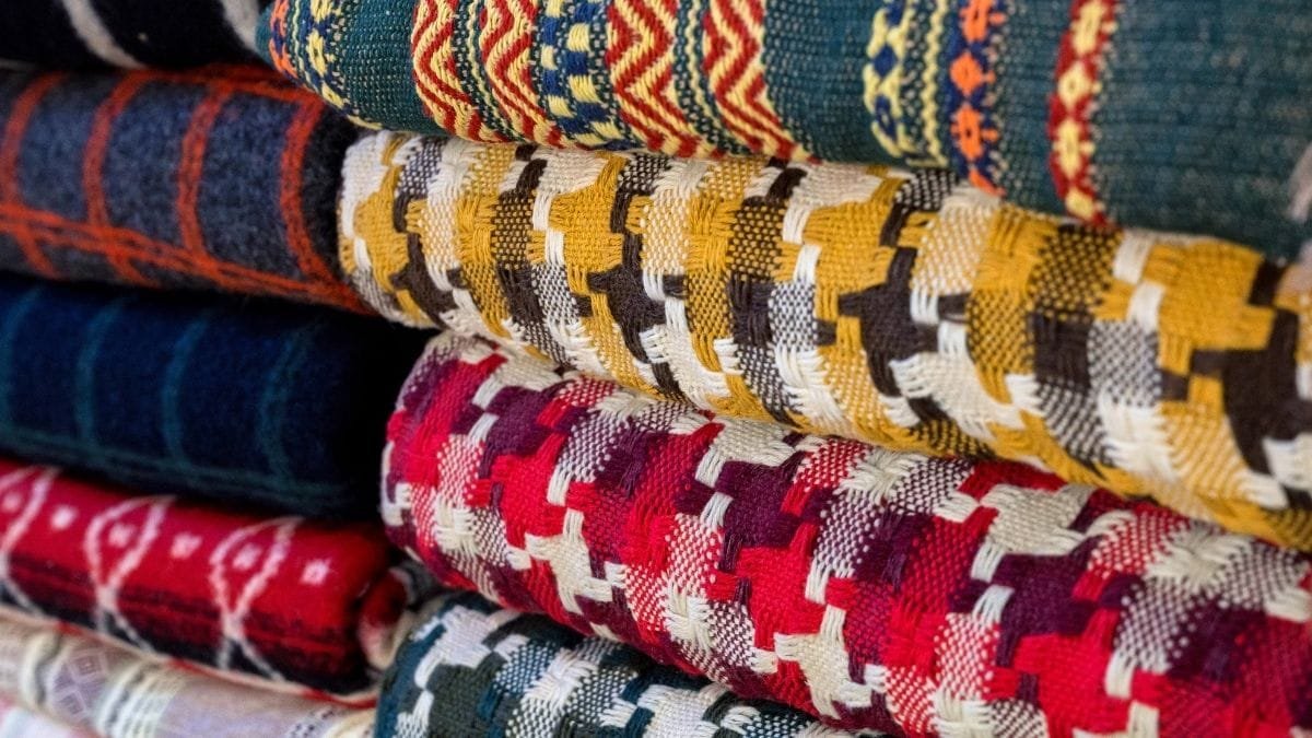 Stack of colorful woven material with intricate patterns and textures