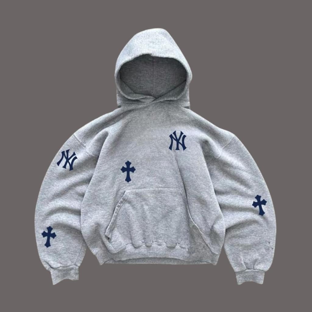 Model wearing a matching athleisure sweatsuit in charcoal gray, standing in a modern gym studio.