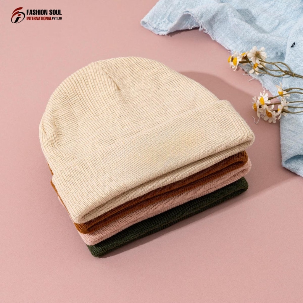 The interior of a beanie manufacturing shop showing knitting machines and sample hats in Colorado-themed colors.