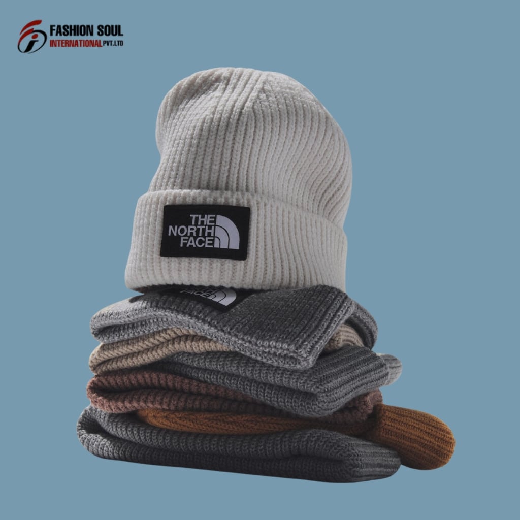 Close-up of hands stitching a soft knit beanie with a unique logo design, on a fabric swatch labeled “Pennsylvania.”