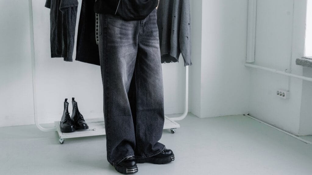 Person wearing stylish black baggy cargo jeans with chunky boots, showcasing modern streetwear fashion