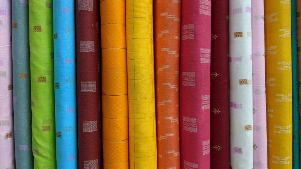 A selection of patterned fabric rolls in various colors and designs, ideal for creating unique and stylish garments or home furnishings