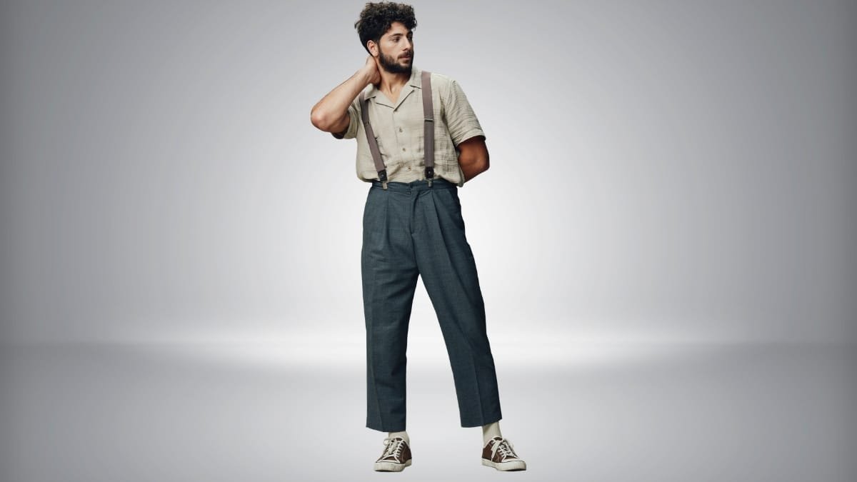 Man wearing 1950s-inspired outfit with high-waisted trousers, suspenders, and short-sleeve shirt
