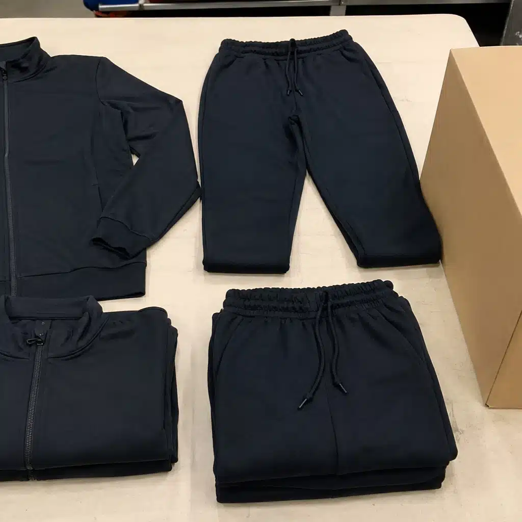 Custom tracksuit manufacturing and export packaging with brushed fleece sportswear ready for international shipment and quality inspection.