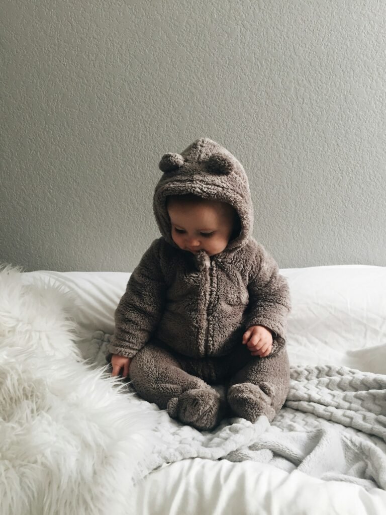 Baby sitting on soft white fabric, baby clothing fabric selection