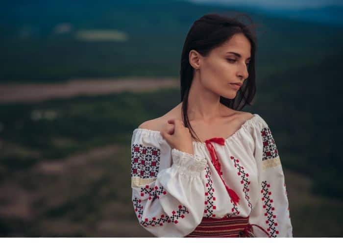 Woman wearing a traditional embroidered blouse in an outdoor mountain setting