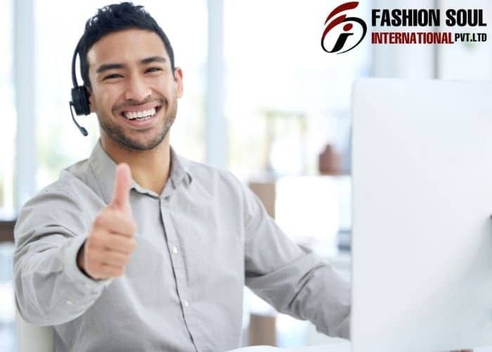 Smiling man giving a thumbs up in a bright office setting