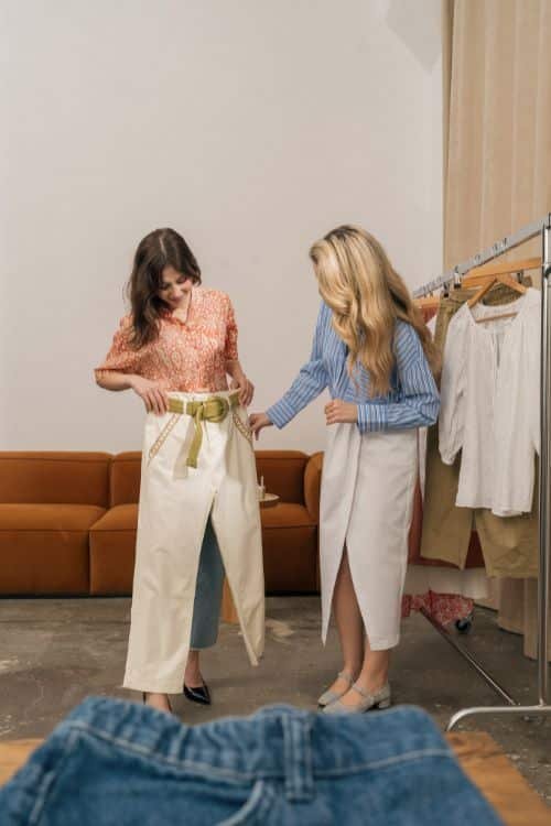 Tailor adjusting a garment with fabric swatches and design samples, showcasing a wide range of customization options for fashion manufacturing.
