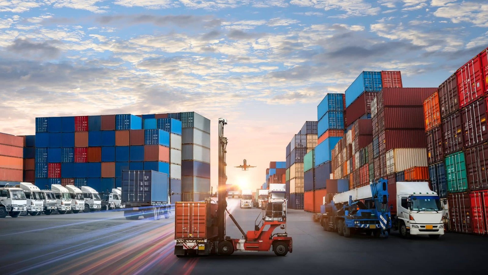 A bustling global shipping hub with stacked cargo containers, transport trucks, a forklift in action, and an airplane taking off at sunset.