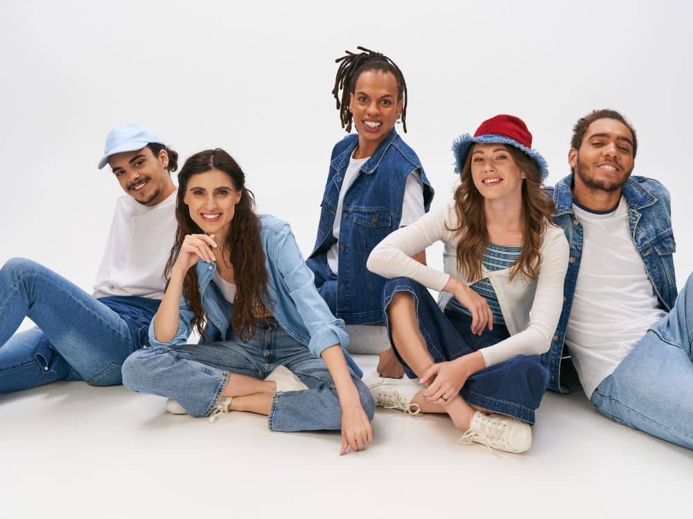 Diverse group of five young adults posing in stylish denim outfits.